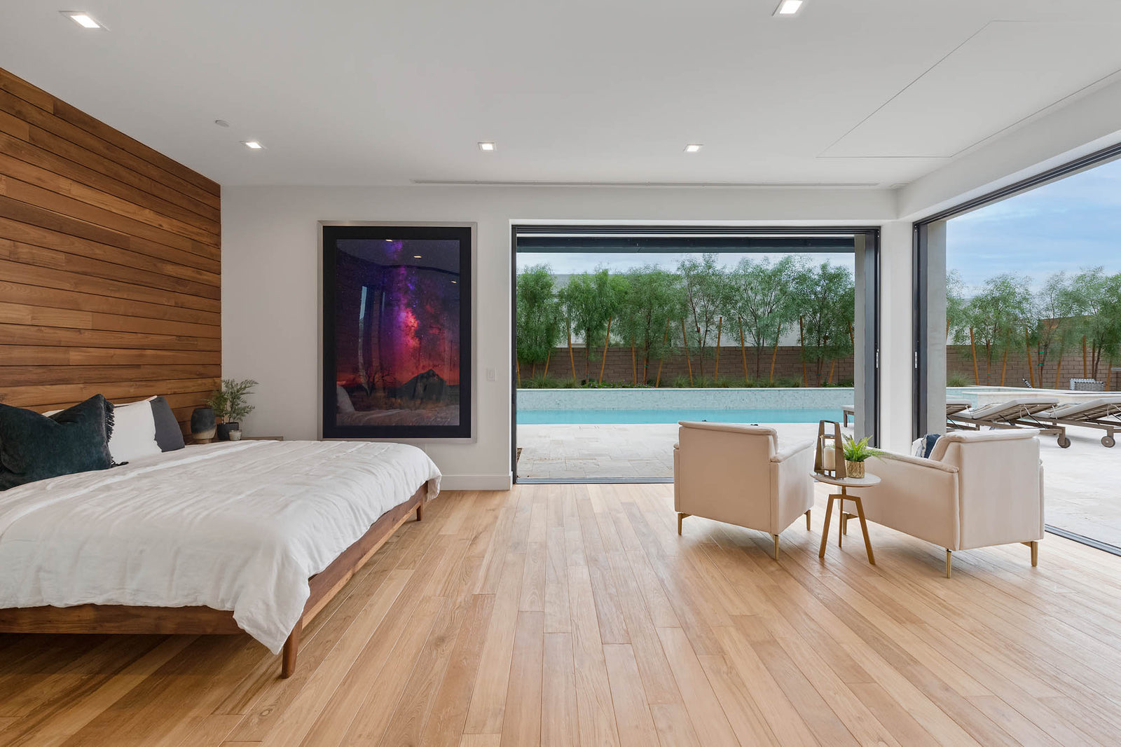 Bedroom with a teak plank accent wall and pale wood floors
