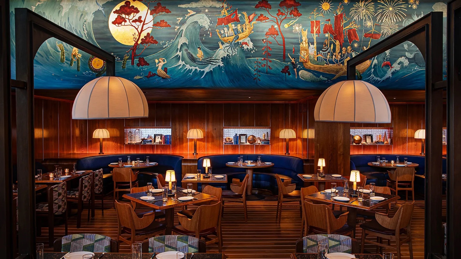 Seahorse restaurant with blue banquettes, wood paneling, striped teak floors, and a painted ocean mural